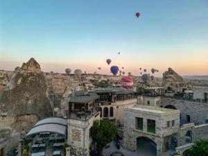 a group of hot air balloons flying over a city at Ascension Cave Suites - Special Class in Göreme