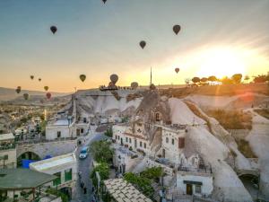 a group of hot air balloons flying over a city at Ascension Cave Suites - Special Class in Göreme