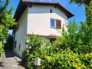 a white house with trees in front of it at Holiday Home Stellina del Sole by Interhome in Brissago