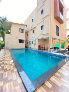 a swimming pool in front of a building at Beach Walk - By Blue waves in Alībāg