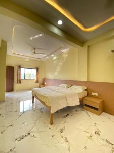 a bedroom with a bed and a marble floor at Beach Walk - By Blue waves in Alībāg