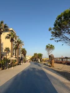 an empty street with palm trees on the side of a road at Sole Inn in Durrës