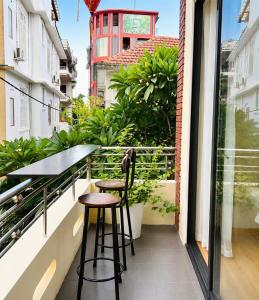 a balcony with a table and two stools at Hue Ancient Hostel in Hue