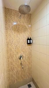 a shower in a tiled bathroom with a blow dryer at Alltrue Lite Hotel Nagoya Hill Batam in Nagoya +16 photos