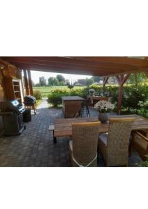 a patio with a table and chairs and a grill at Ferienwohnung Margarethe in Stedesdorf