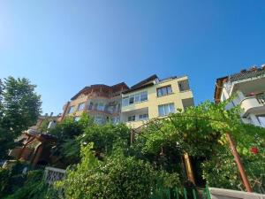 a tall building with trees in front of it at Casa Bianca - Summer residency in Primorsko
