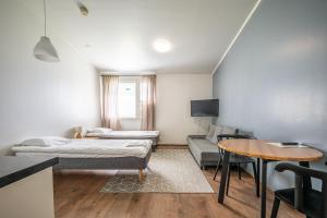 a living room with two beds and a table at LODGE Hostel Kuusamo in Kuusamo