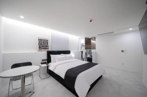 ein Schlafzimmer mit Bett und Tisch und eine Küche in der Unterkunft aiden in Busan + 29 Fotos
