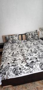 a bed with a black and white blanket and pillows at Casa Bianca - Summer residency in Primorsko