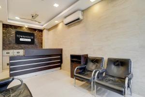 two chairs in a waiting room with a sign on the wall at Townhouse Millenium City Centre in Gurgaon