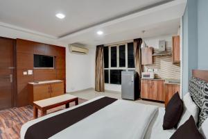 a bedroom with a large bed and a kitchen at Townhouse Millenium City Centre in Gurgaon +37 photos