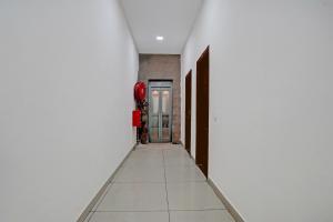 a hallway with white walls and a red fire hydrant at Super Collection O by OYO Patiala Road Crossway Zirakpur Formerly Lavish in Zirakpur