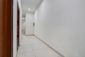 an empty hallway with a white tile floor at Super Collection O by OYO Patiala Road Crossway Zirakpur Formerly Lavish in Zirakpur +23 photos
