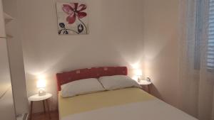 a bedroom with a bed with two lights on two tables at Apartman Iva in Kaštela