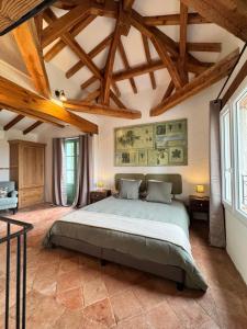 a bedroom with a large bed in a room with wooden ceilings at Cuq en Terrasses in Cuq-Toulza