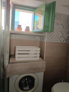 a bathroom with a washing machine and a green cabinet at Trullo Le Tre Sorelle in Cisternino +37 photos