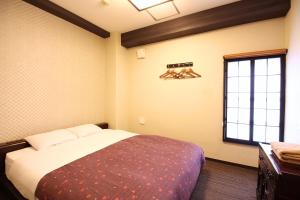 a bedroom with a bed and a window at K's House Tokyo Oasis - Quality Hostel in Asakusa in Tokyo