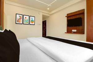 a bedroom with a bed and a flat screen tv at Super Collection O Newtown Bus Stand Formerly The Executive Suites in New Town +29 photos