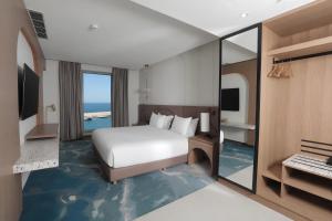 a hotel room with a bed and a view of the ocean at voco Beirut Central District by IHG in Beirut +54 photos