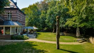 a sculpture of a tree in a yard next to a building at Boutique hotel Roosendaelhof in Geel