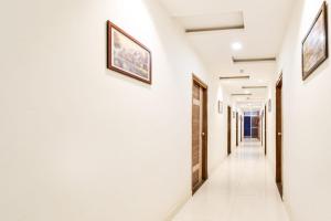 a corridor of a hospital with white walls and art on the walls at Super Townhouse Raniganj Formerly Devi Residency in Hyderabad