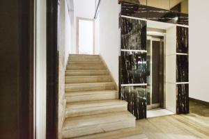 a staircase in a building with a glass wall at Super Townhouse Raniganj Formerly Devi Residency in Hyderabad