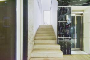 a staircase in a building with a glass wall at Super Townhouse Raniganj Formerly Devi Residency in Hyderabad +26 photos