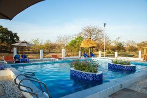 a swimming pool with chairs and an umbrella at Angel homestay hotel in Mikumi