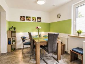 a dining room with green walls and a wooden table and chairs at Holiday Home Bailey by Interhome in Laupheim