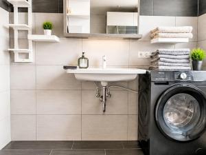 a bathroom with a sink and a washing machine at Apartment Wohnung Gartenblick by Interhome in Laupheim