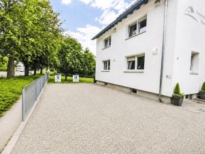 a white building with a fence next to it at Apartment Wohnung Gartenblick by Interhome in Laupheim