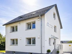 a white house with a black roof at Apartment Wohnung Gartenblick by Interhome in Laupheim