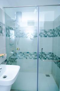 a bathroom with a glass shower and a sink at JAI REST In in Jaffna +21 photos