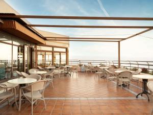 ein Restaurant mit Tischen und Stühlen auf einem Balkon in der Unterkunft Ona Princesa Playa in Marbella