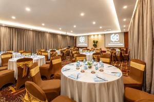 a banquet hall with white tables and chairs and a podium at G8 Diamond Hotel Saigon in Ho Chi Minh City