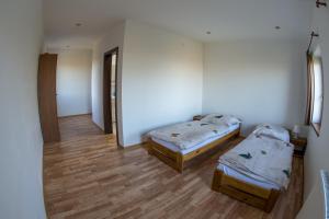 two beds in a room with wooden floors at Vinum Vivo winery in Nevidzany