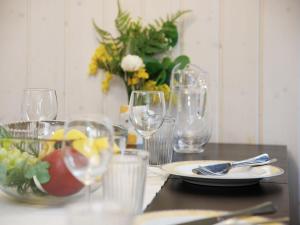 a table with wine glasses and a plate of food at Holiday Home Chalet Guldeli by Interhome in Kandergrund