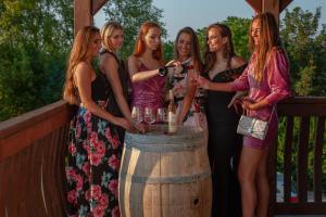 a group of women standing around a barrel pouring wine at Vinum Vivo winery in Nevidzany