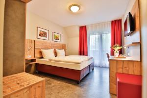 a bedroom with a bed in a room with red curtains at Hotel Gut Funkenhof in Sundern +36 photos