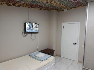 a bedroom with a bed and a tv on the wall at Гостевой дом Sartepo in Samarkand