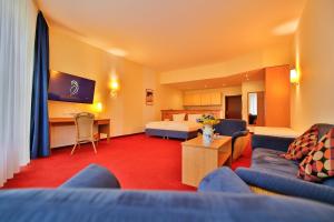 a living room with a couch and a bed at Hotel Gut Funkenhof in Sundern