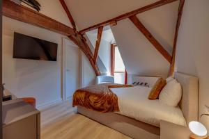 a bedroom with a bed and a tv in a room at Boutique hotel Roosendaelhof in Geel