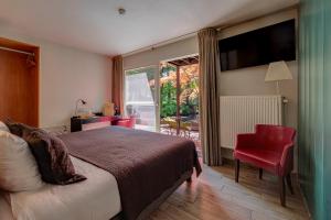 a hotel room with a bed and a red chair at Boutique hotel Roosendaelhof in Geel