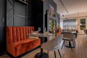 a restaurant with orange chairs and a table with glasses at Boutique hotel Roosendaelhof in Geel