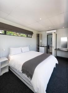 a bedroom with a large white bed and a television at SleepOver Phabeni in Hazyview +33 photos
