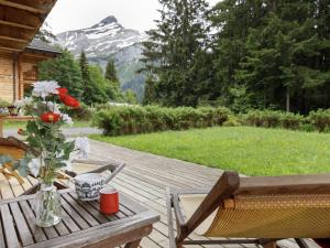 a wooden deck with a table with a vase of flowers at Chalet Dörfli by Interhome in Les Diablerets