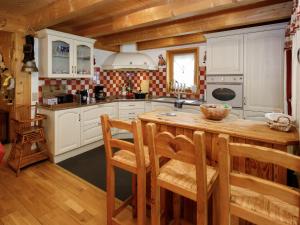 a kitchen with white cabinets and a wooden table at Chalet Dörfli by Interhome in Les Diablerets