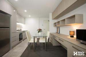 a kitchen with a table and a dining room at KozyGuru | Epping | Stylish 1 Bedroom Apartment in Epping