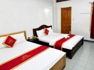 a room with two beds with red and white sheets at Hồng Phát 68 Hotel in Ho Chi Minh City