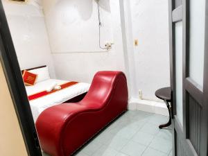 a red chair in a small room with a bed at Hồng Phát 68 Hotel in Ho Chi Minh City